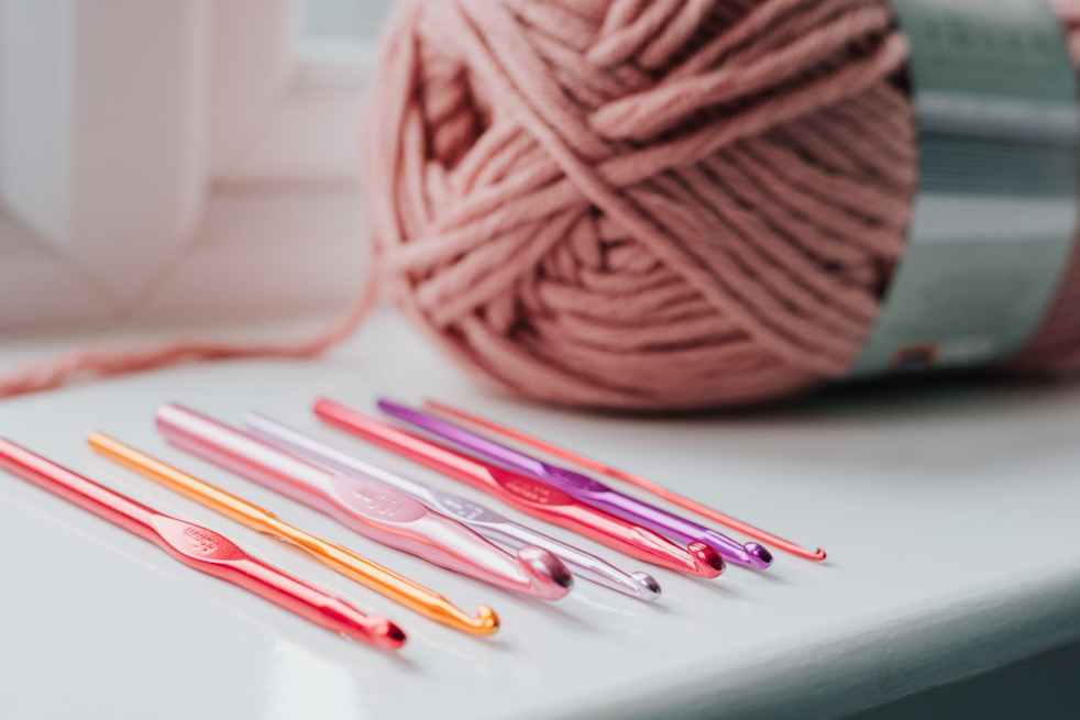 crochet needles and threads on windowsill